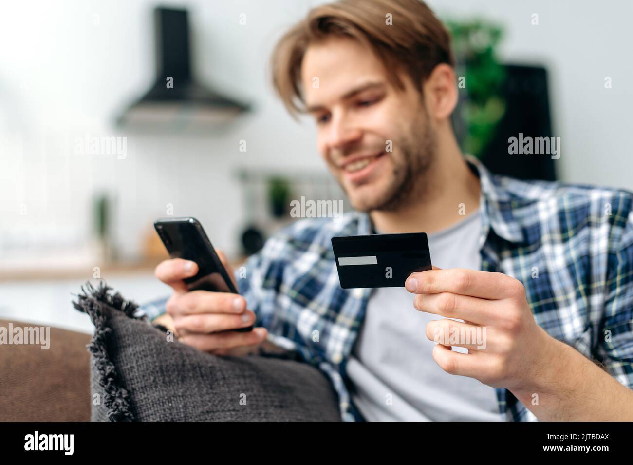 Defocused caucasian attractive stylish guy, sit on a sofa in the living