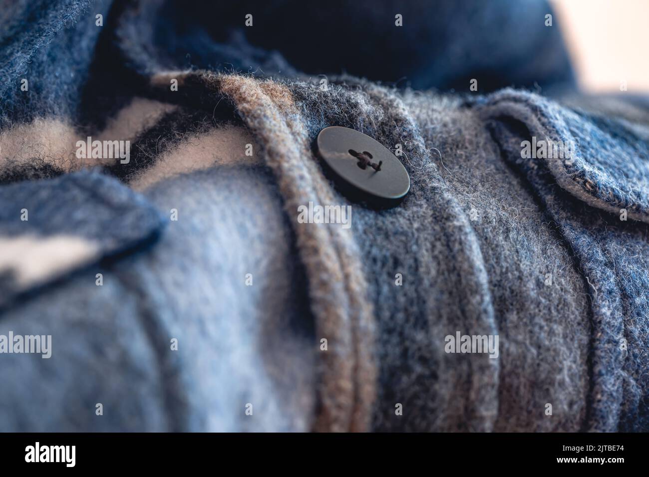 Button on a warm blue shirt, macro shot. Stock Photo
