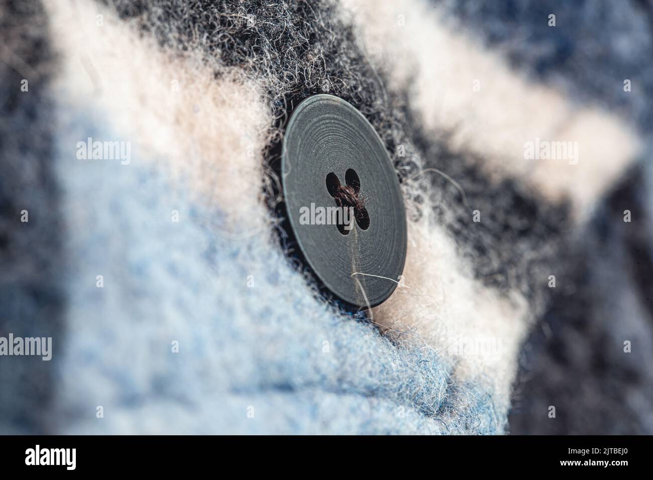 Button on a warm blue shirt, macro shot. Stock Photo