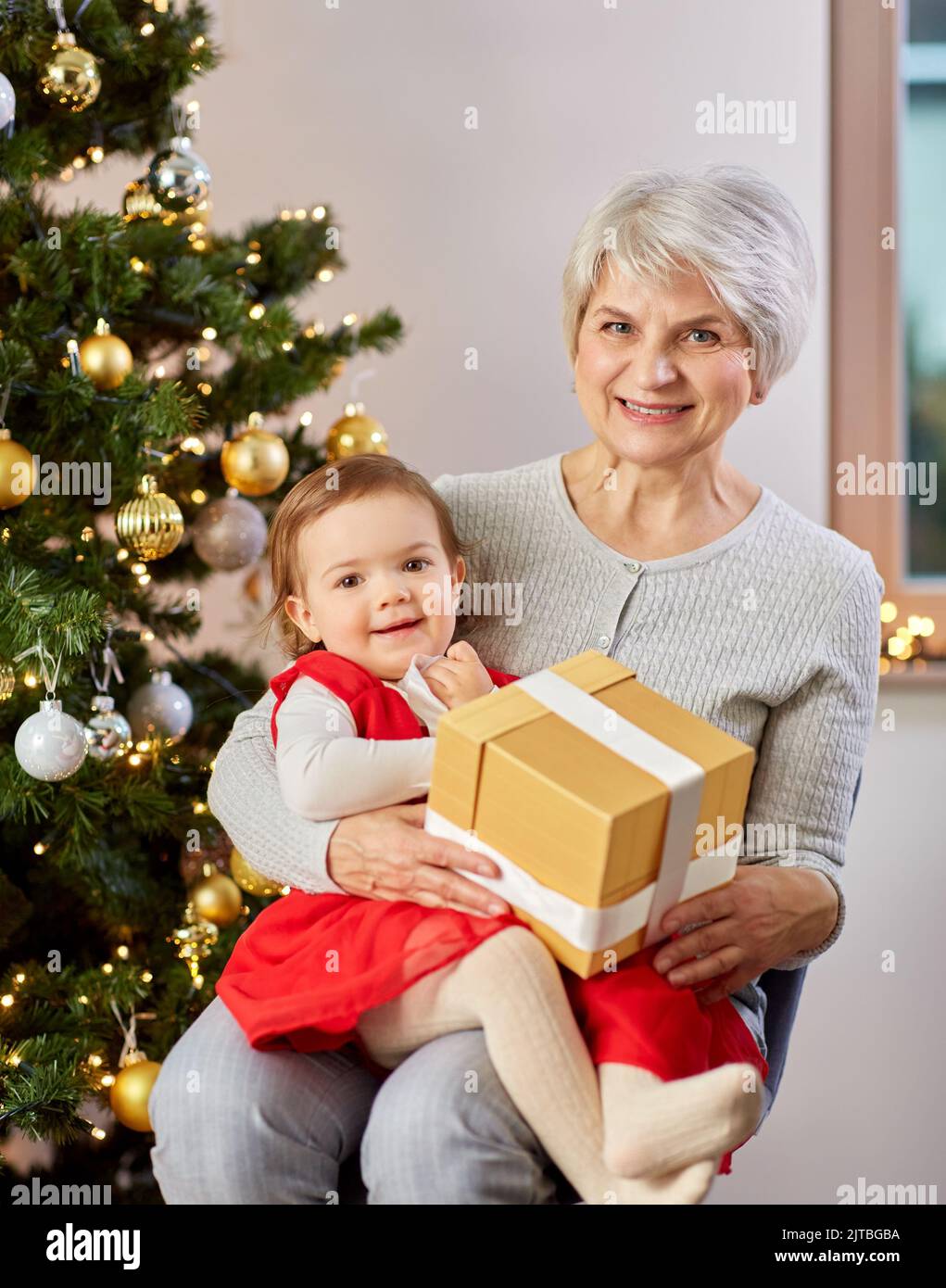 https://c8.alamy.com/comp/2JTBGBA/grandmother-and-baby-girl-with-christmas-gift-2JTBGBA.jpg
