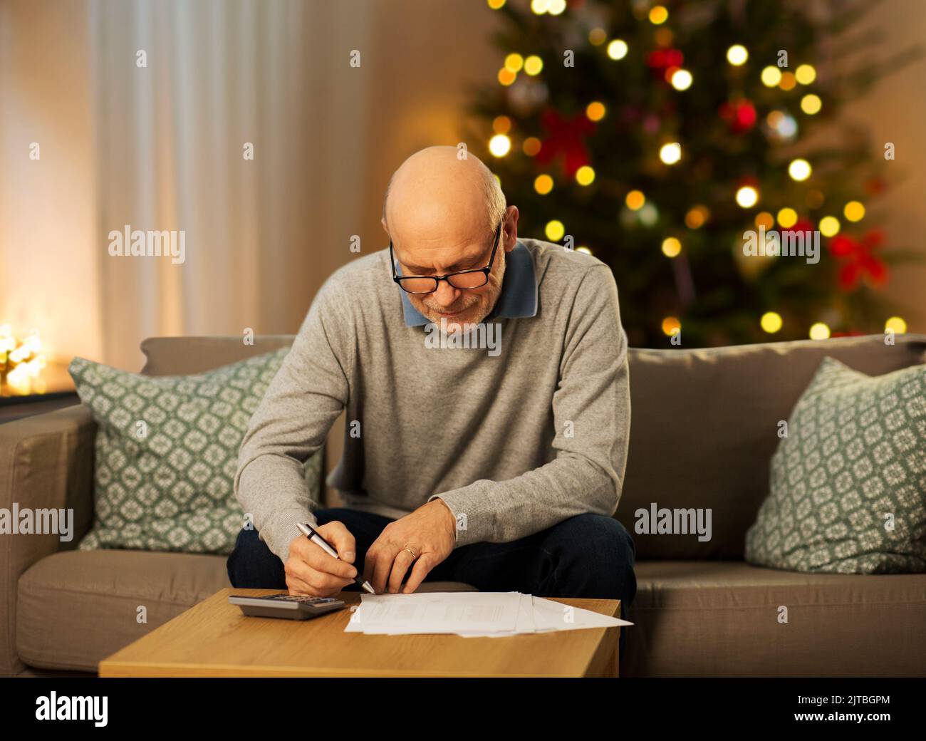 senior man with bills and calculator on christmas Stock Photo