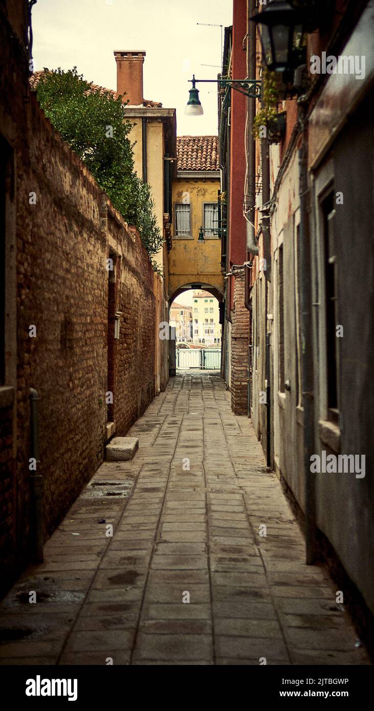 A vertical shot of a narrow street with an arched passage Stock Photo ...