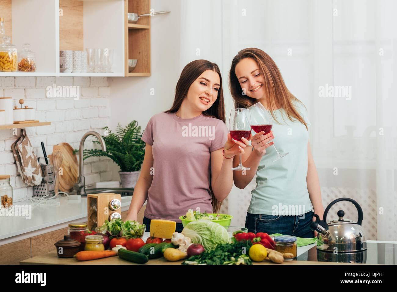 two young women kitchen friends evening relaxation Stock Photo - Alamy