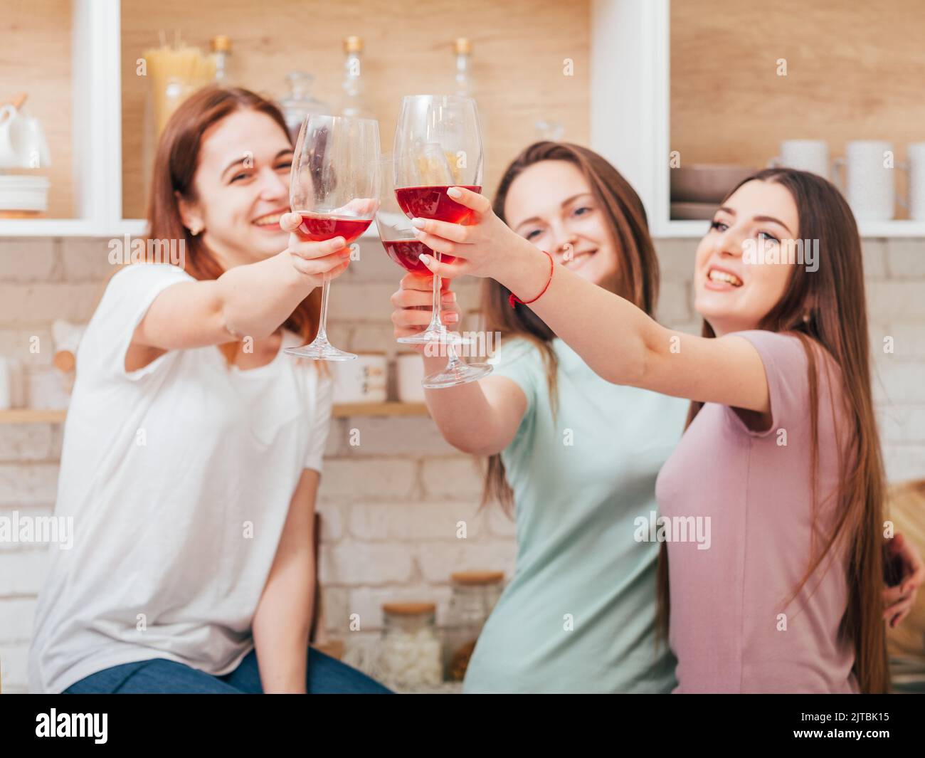cheers kitchen party women clink glass red wine Stock Photo Alamy