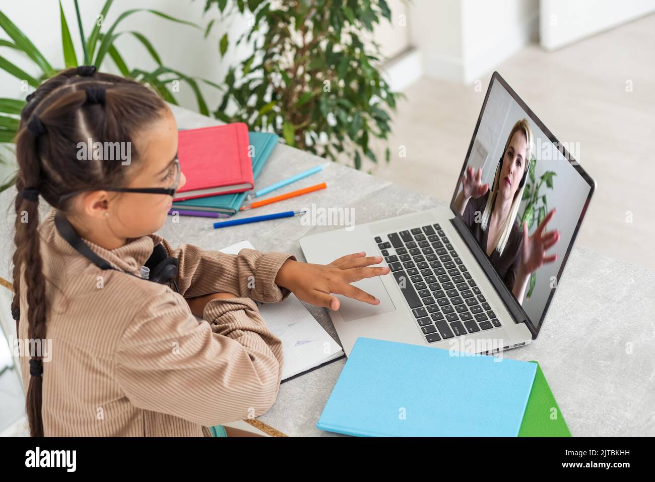 ELearning. Shocked Little Schoolgirl Looking At Laptop Wearing