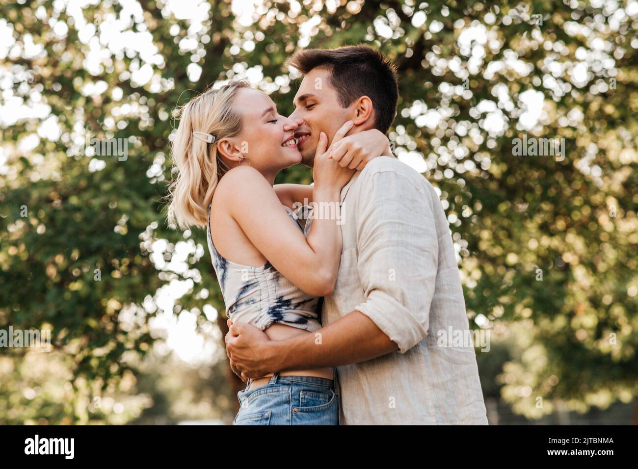 happy young couple kissing and hugging outdoors Stock Photo - Alamy