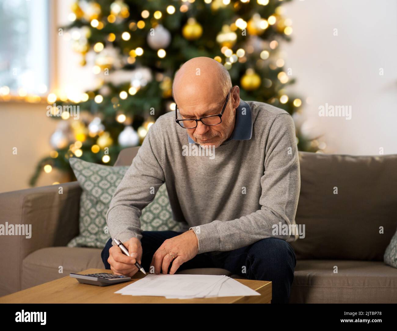 senior man with bills at home on christmas Stock Photo