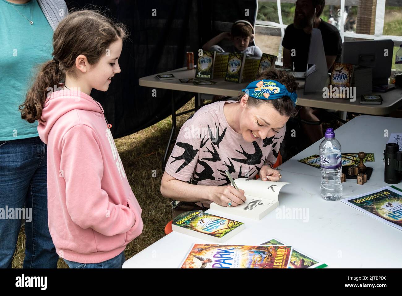 M G Leonard the best selling children's author signs a dedication in one of her books to a young fan at Cromwell Bottom Nature Reserve Open Day Stock Photo