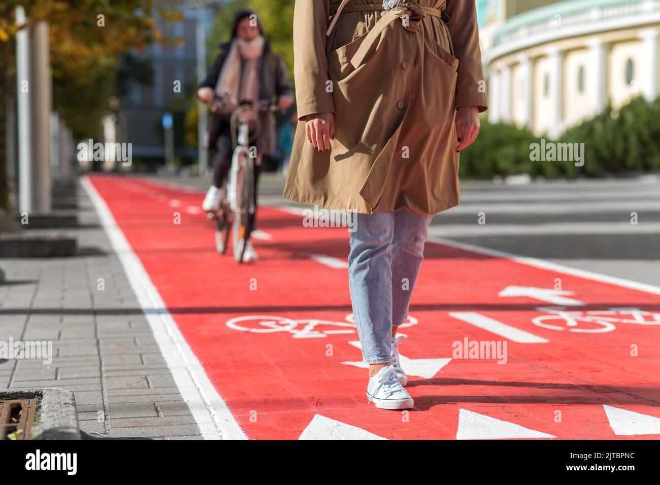 woman walking along bike lane or road for bicycles Stock Photo