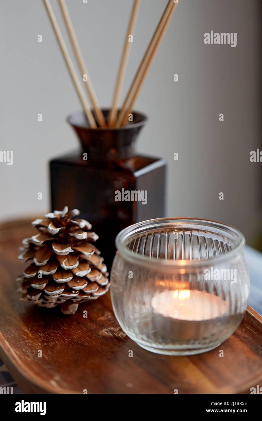 candle holder, reed diffuser and pine cone at home Stock Photo Alamy