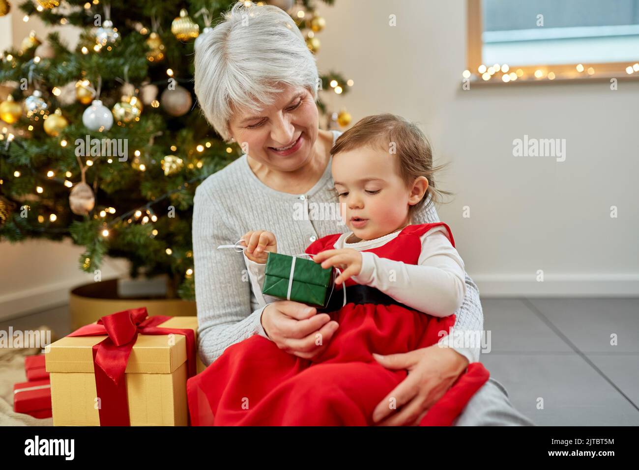 Excited Grandmother Receiving Christmas Gift From Granddaughter At Home  Stock Photo - Alamy