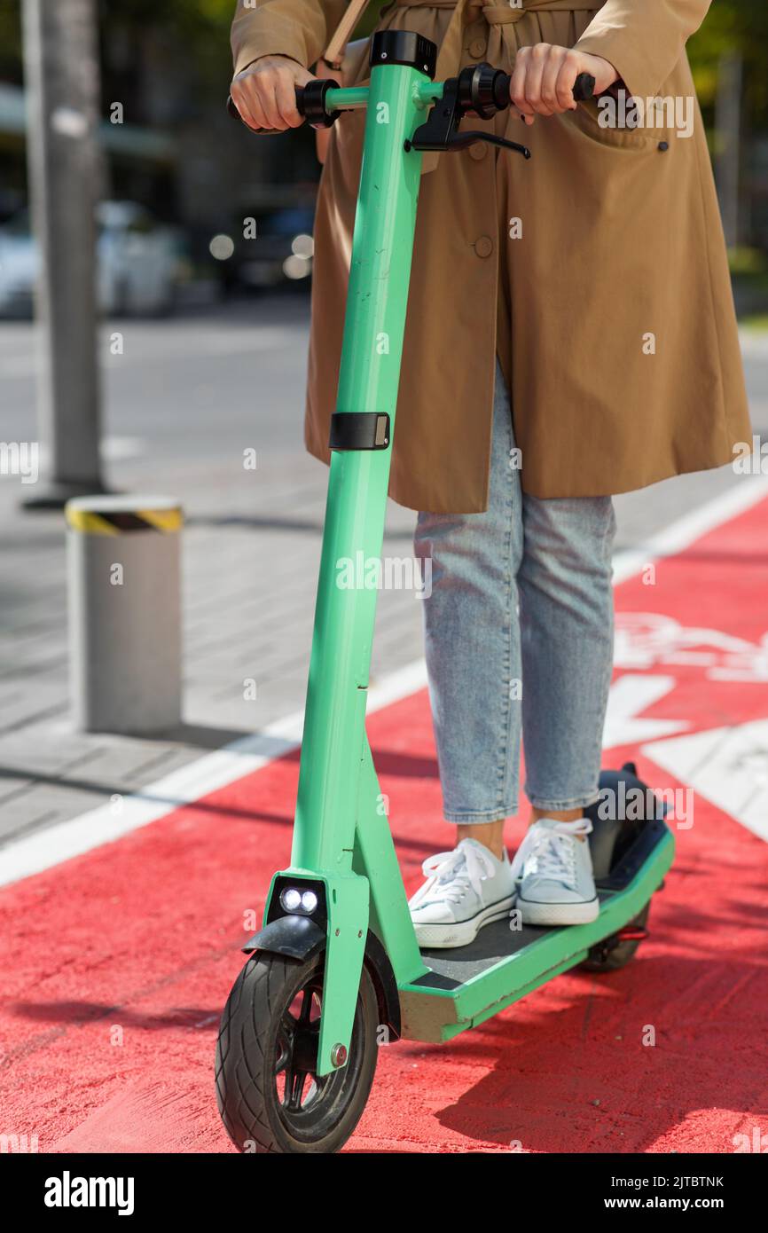 woman riding scooter along bike lane road in city Stock Photo Alamy