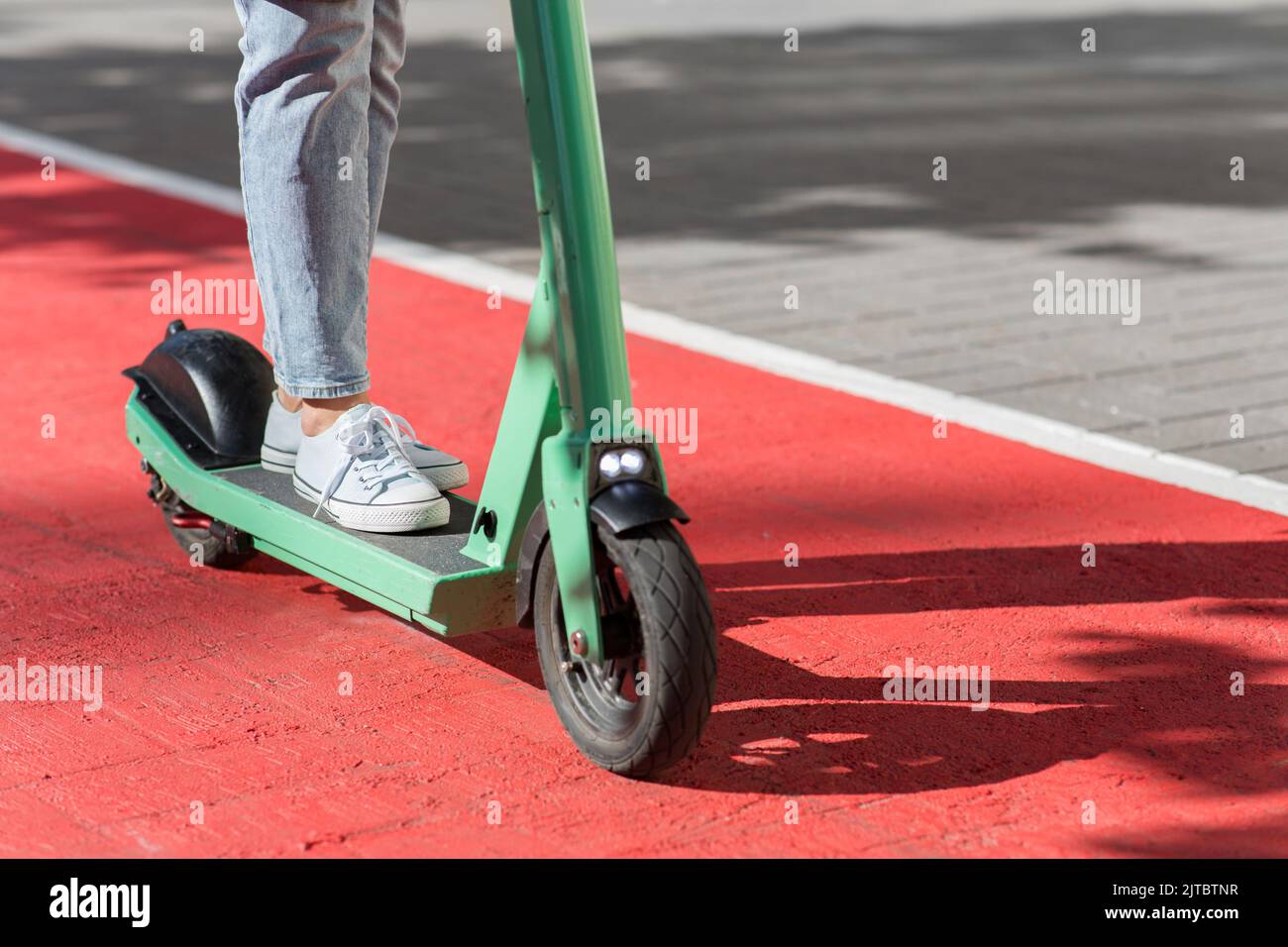 woman riding scooter along bike lane road in city Stock Photo Alamy