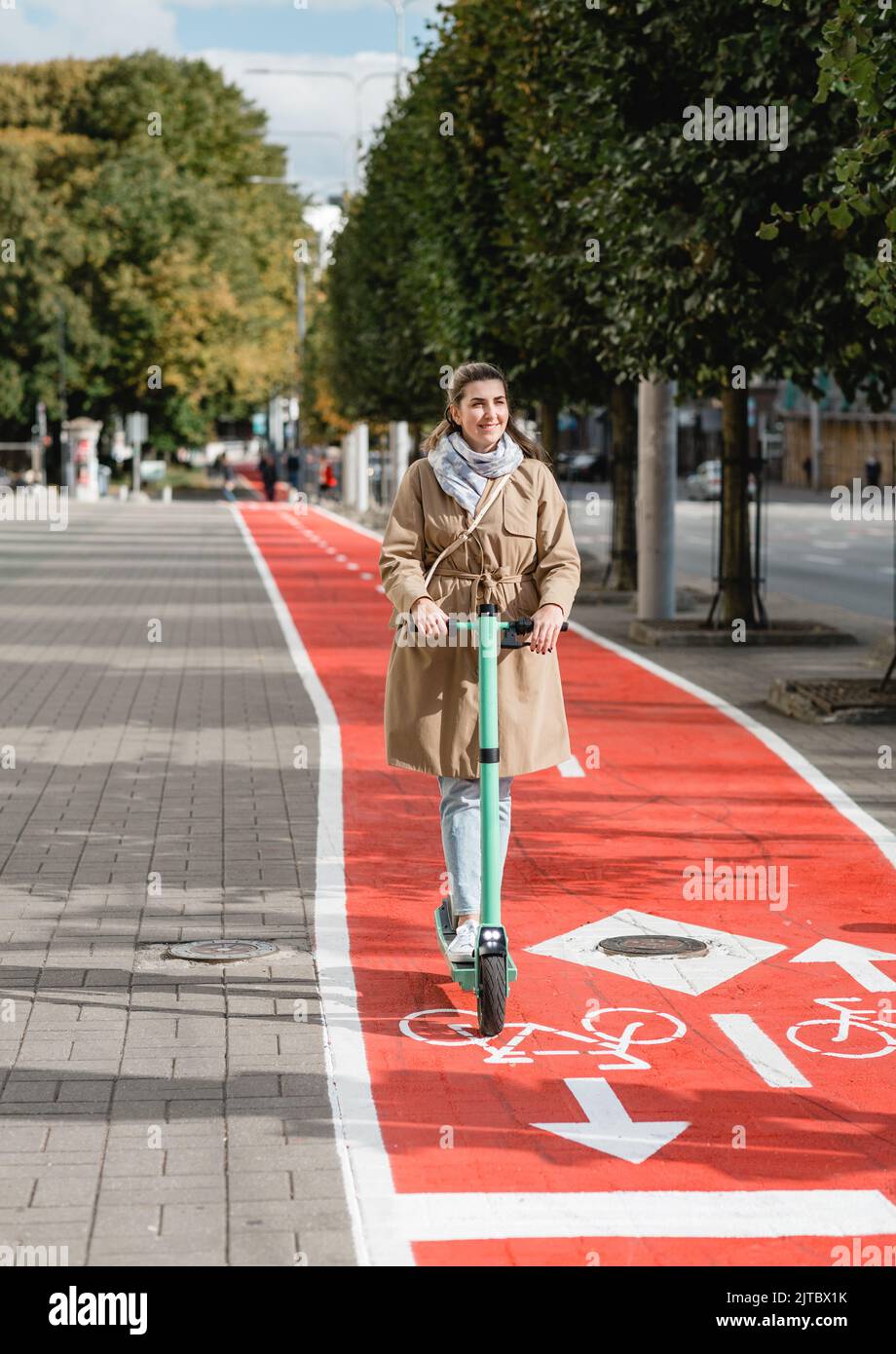 woman riding scooter along bike lane road in city Stock Photo Alamy