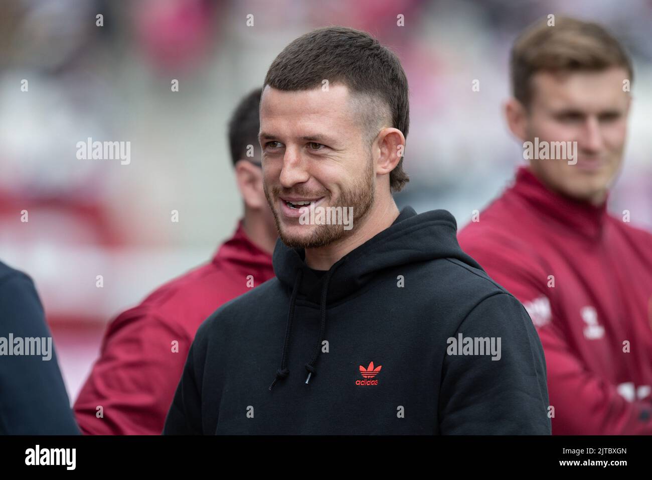 Cade Cust 6 of Wigan Warriors in the dug out ahead of today's game