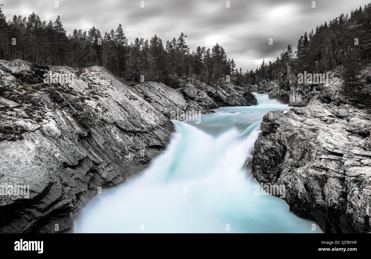 Picture of a waterfall in Norway, black and white with the orogonal colour of the water, colour splash, horizontal Stock Photo