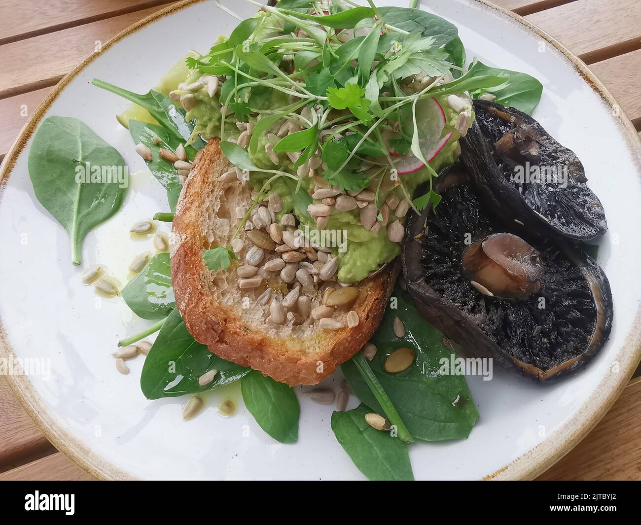 Plant based meal of mashed avocado on sourdough with mushrooms Stock Photo