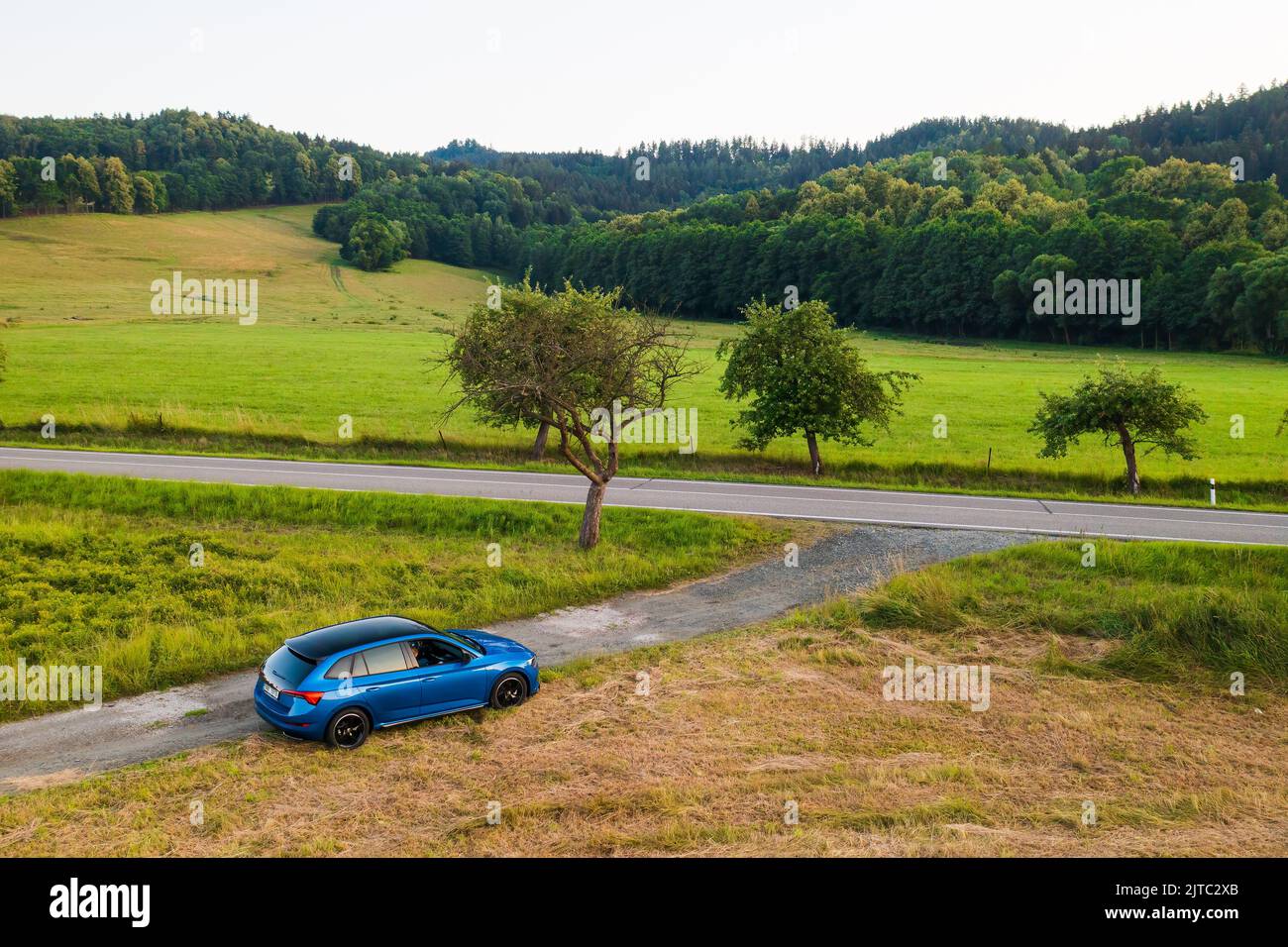 Blue Skoda Scala car standing on the countryside road with amazing view on the valley and lush trees, aerial view, August 2022, Dolni Morava, Czech Republic Stock Photo