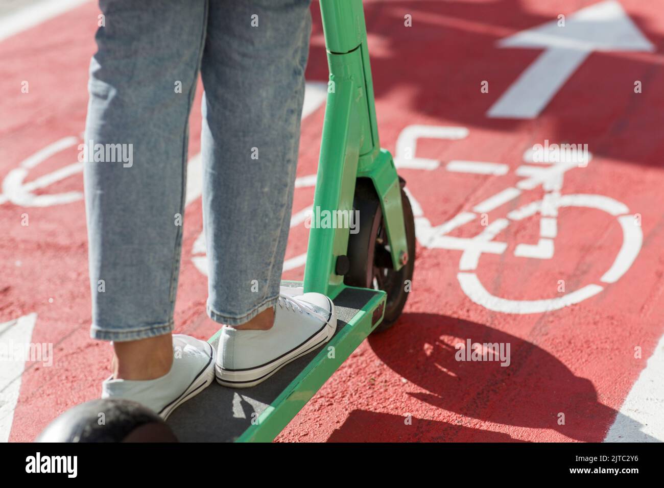 woman riding scooter along bike lane road in city Stock Photo Alamy