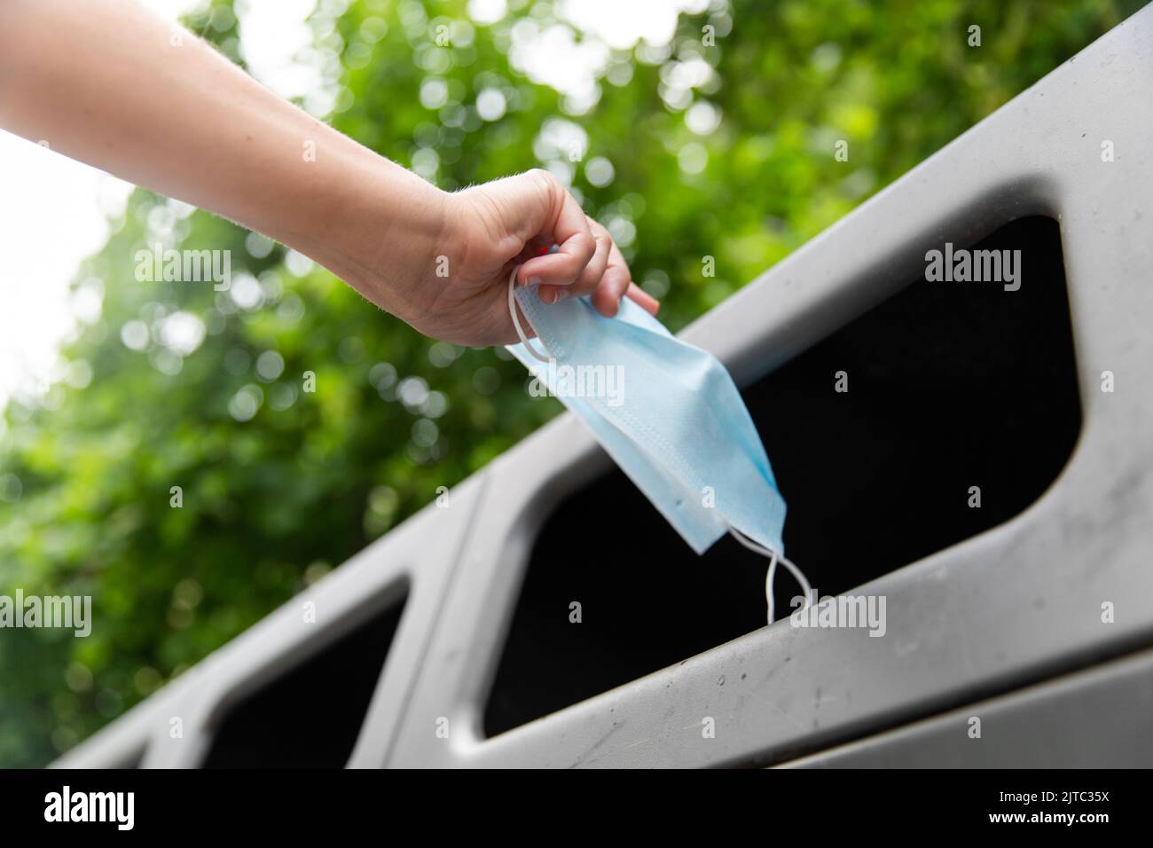 close up of hand throwing used mask in trash Stock Photo Alamy
