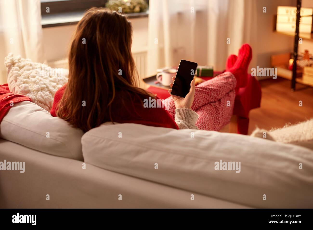 Woman texting home rear view hi-res stock photography and images - Alamy