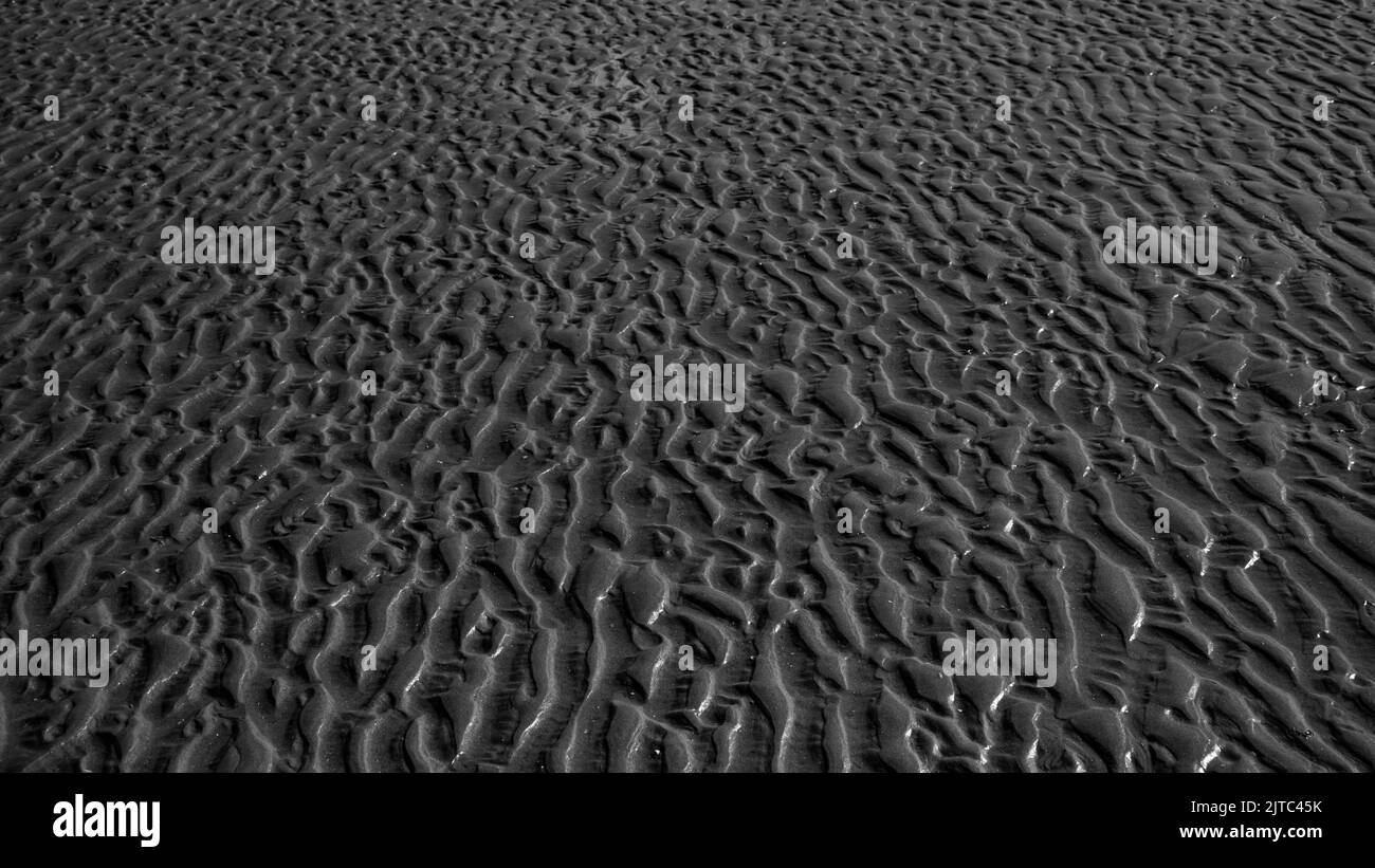 ondulations et traces de pas dans le sable humide sur la plage. Mer et Océan Stock Photo