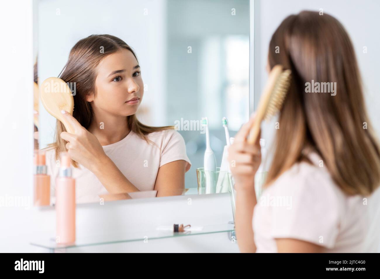 teenage girl brushing hair with comb at bathroom Stock Photo Alamy