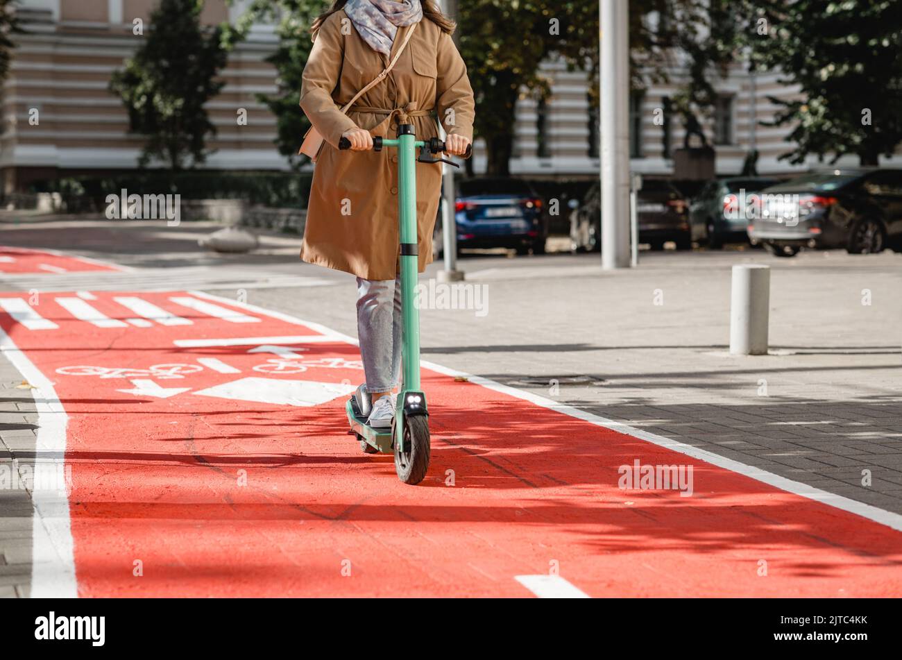 woman riding scooter along bike lane road in city Stock Photo Alamy