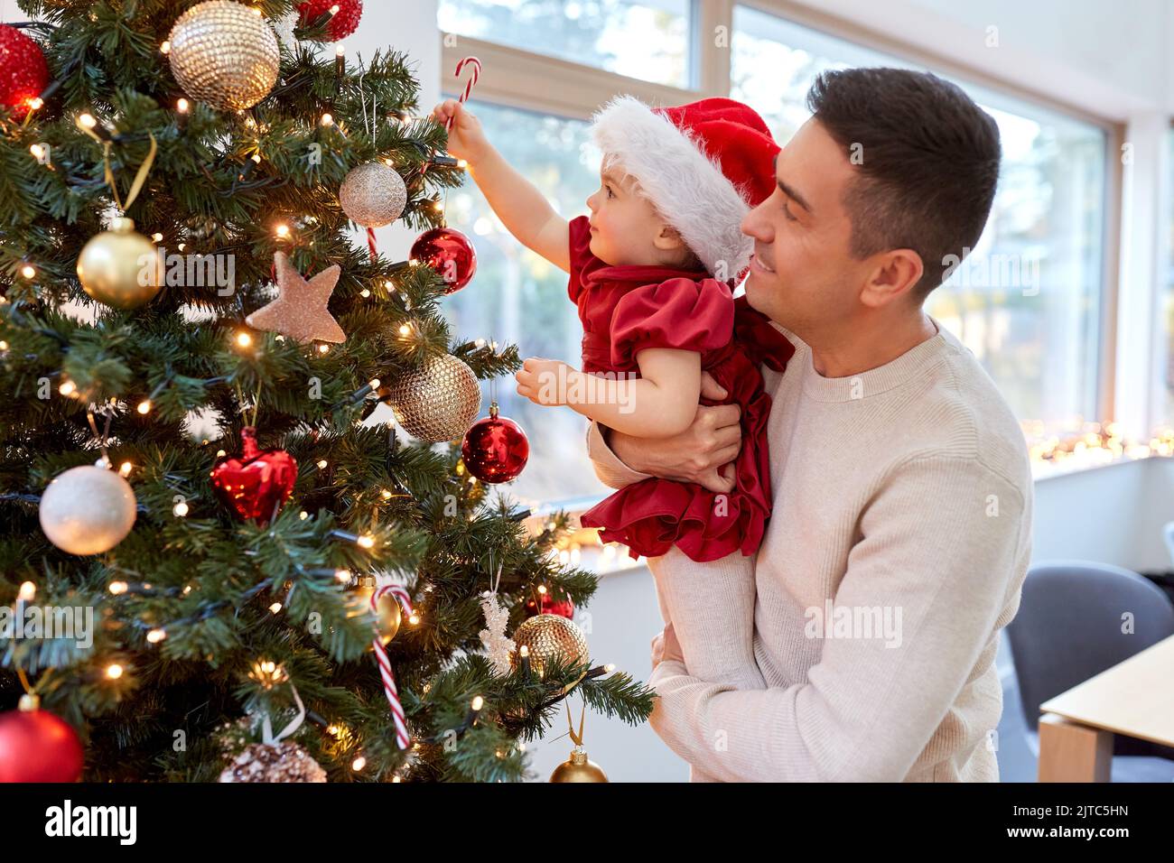 happy father and baby girl decorate christmas tree Stock Photo - Alamy