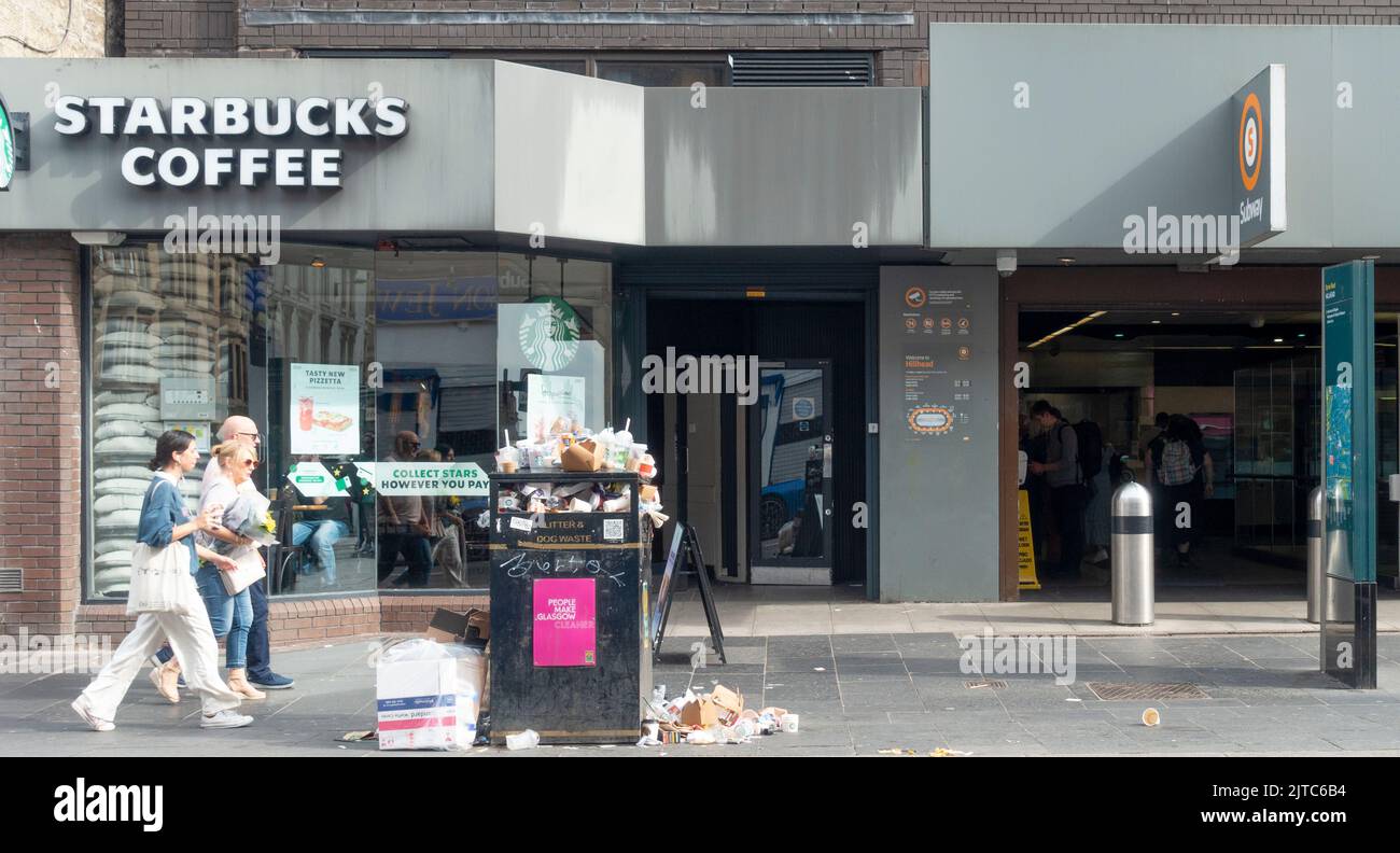 Overflowing litter bin on the pavement outside a Starbucks Coffee Shop on Byres Road, central Glasgow, during a strike by Council garbage collectors. Stock Photo