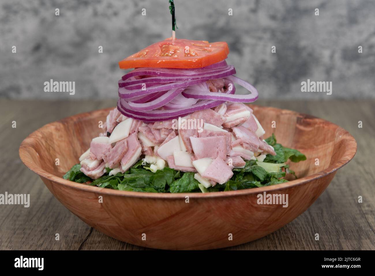 Antipasto salad is delicately balanced tall with pepperoni, cotto salami, and romaine lettuce is a meal within itself. Stock Photo