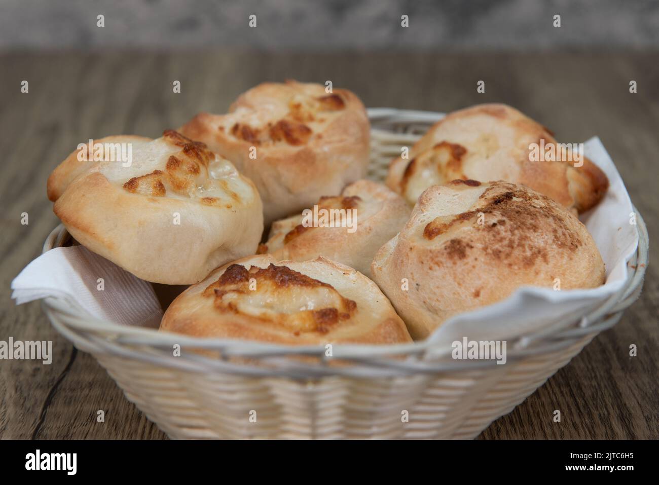Full basket of garlic and cheese rolls makes the perfect appetizer before an Italian food meal. Stock Photo