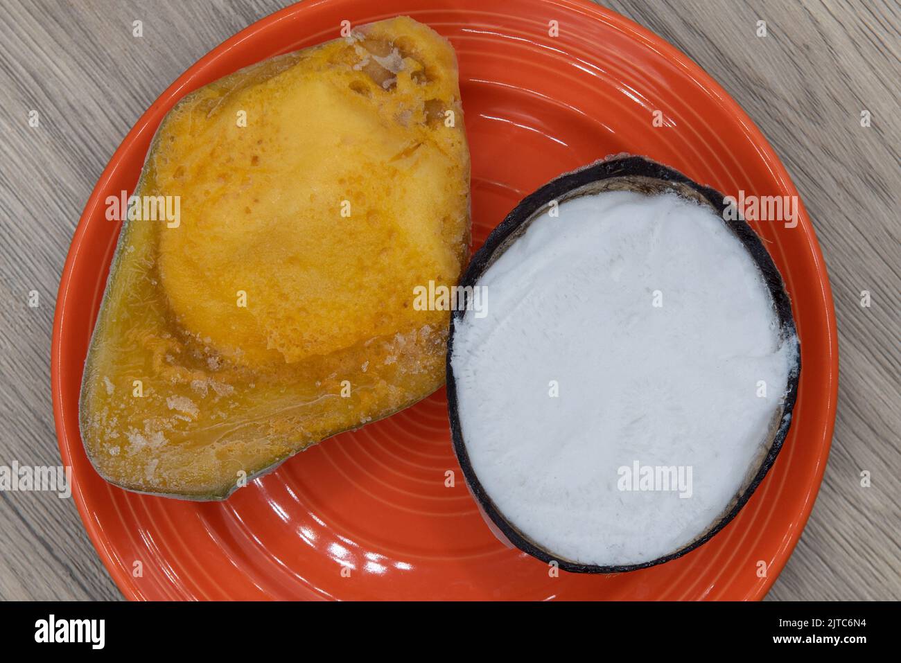 Overhead view of frozen dessert is served with an authentic Italian dish with coconut shell ice cream served with a iced mango. Stock Photo
