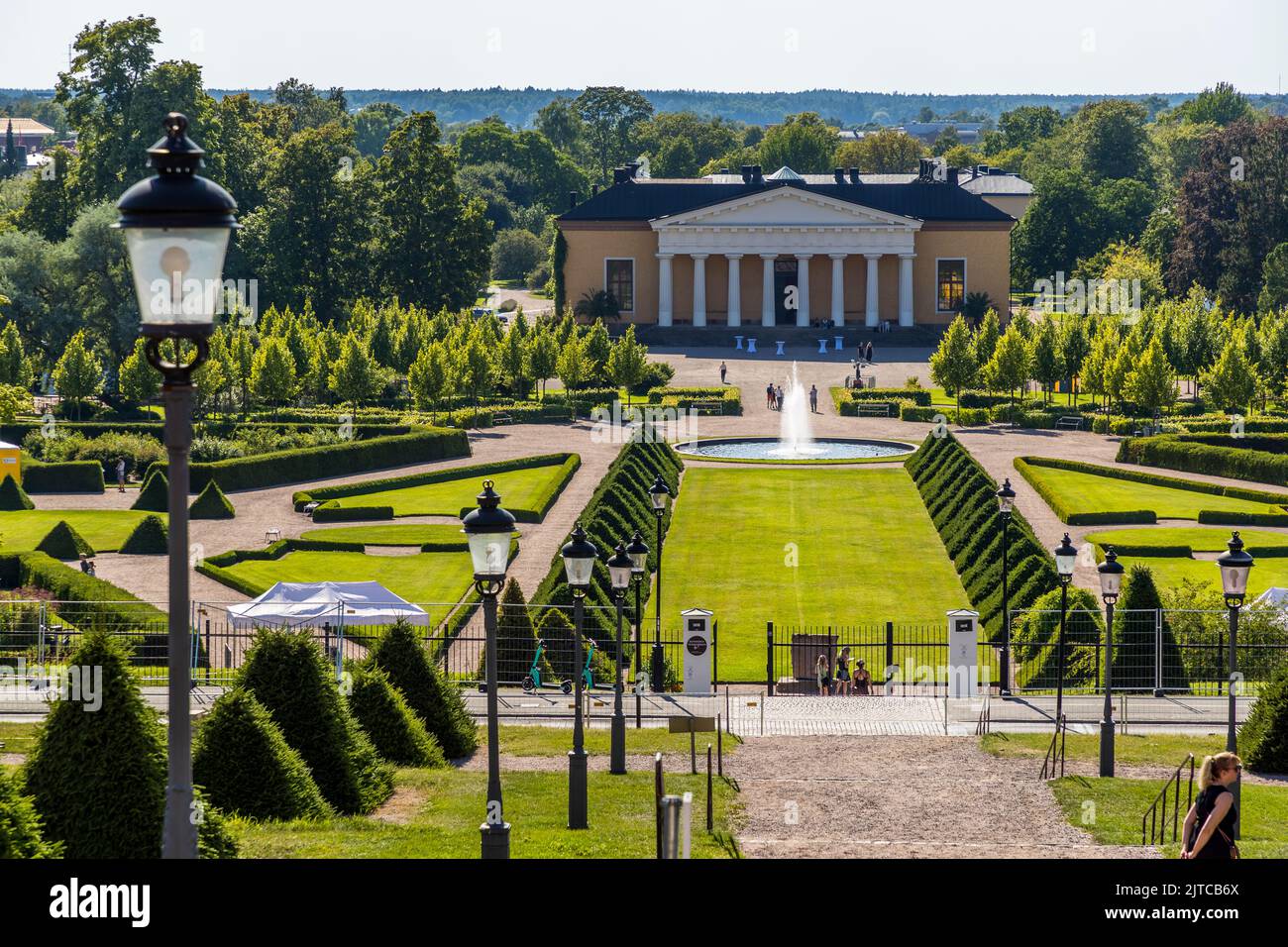 Uppsala Castle Park in Sweden with the Orangery in the background. The trellis of pyamid cut fir trees has a blemish Stock Photo