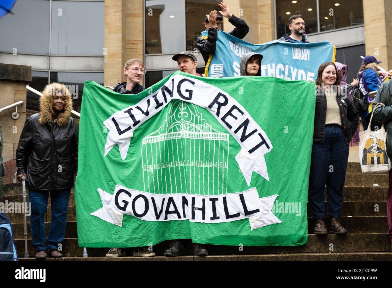 Living Rent (tenants union in Scotland) Govanhill banner held by demonstrators at joint union strike rally in Glasgow on 26 August 2022, Scotland, UK Stock Photo