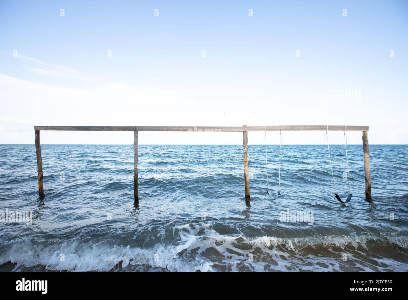 Wooden swing set on the ocean in Hopkins Belize Stock Photo