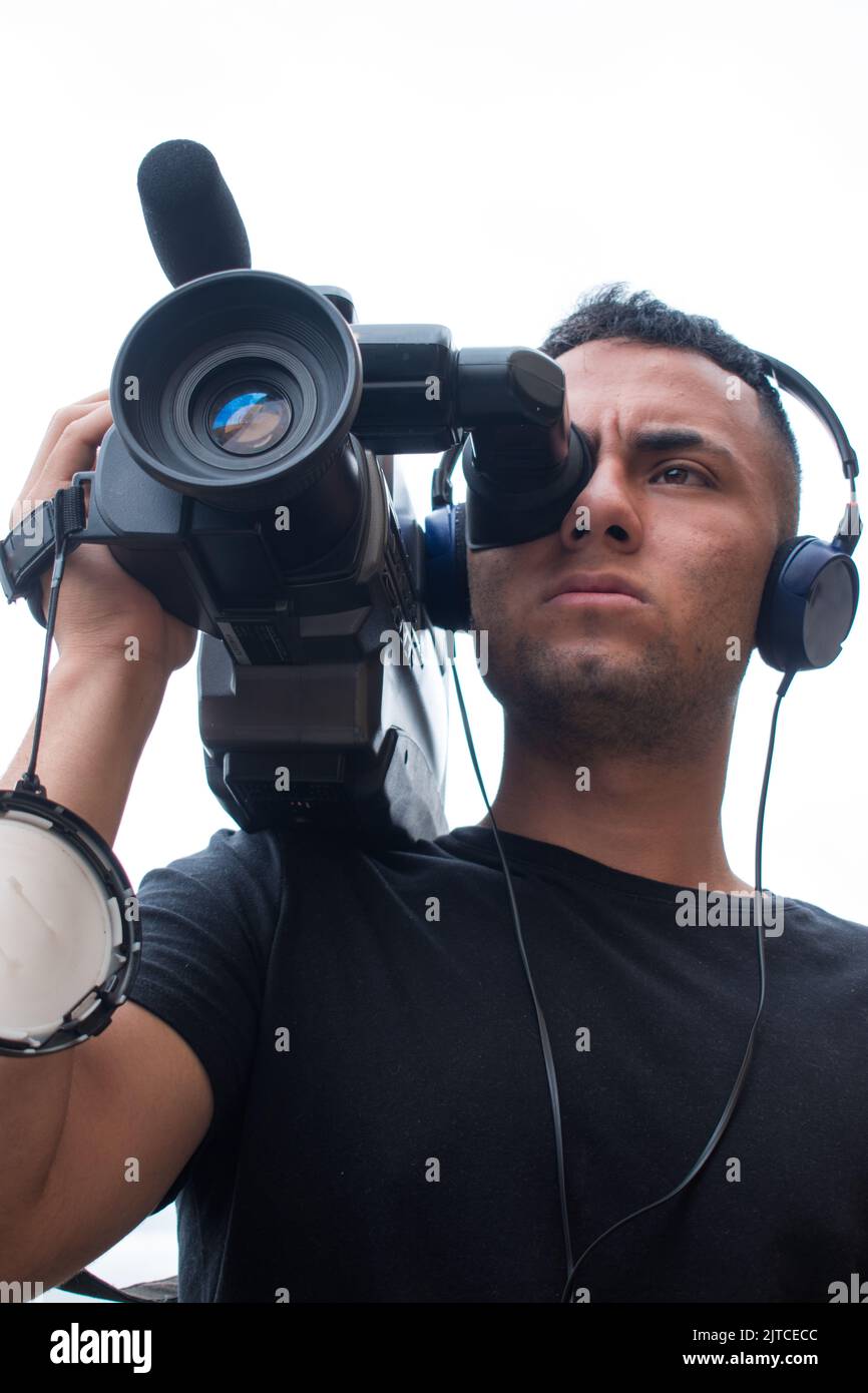 Man filming with a big video camera in a cloudy day Stock Photo