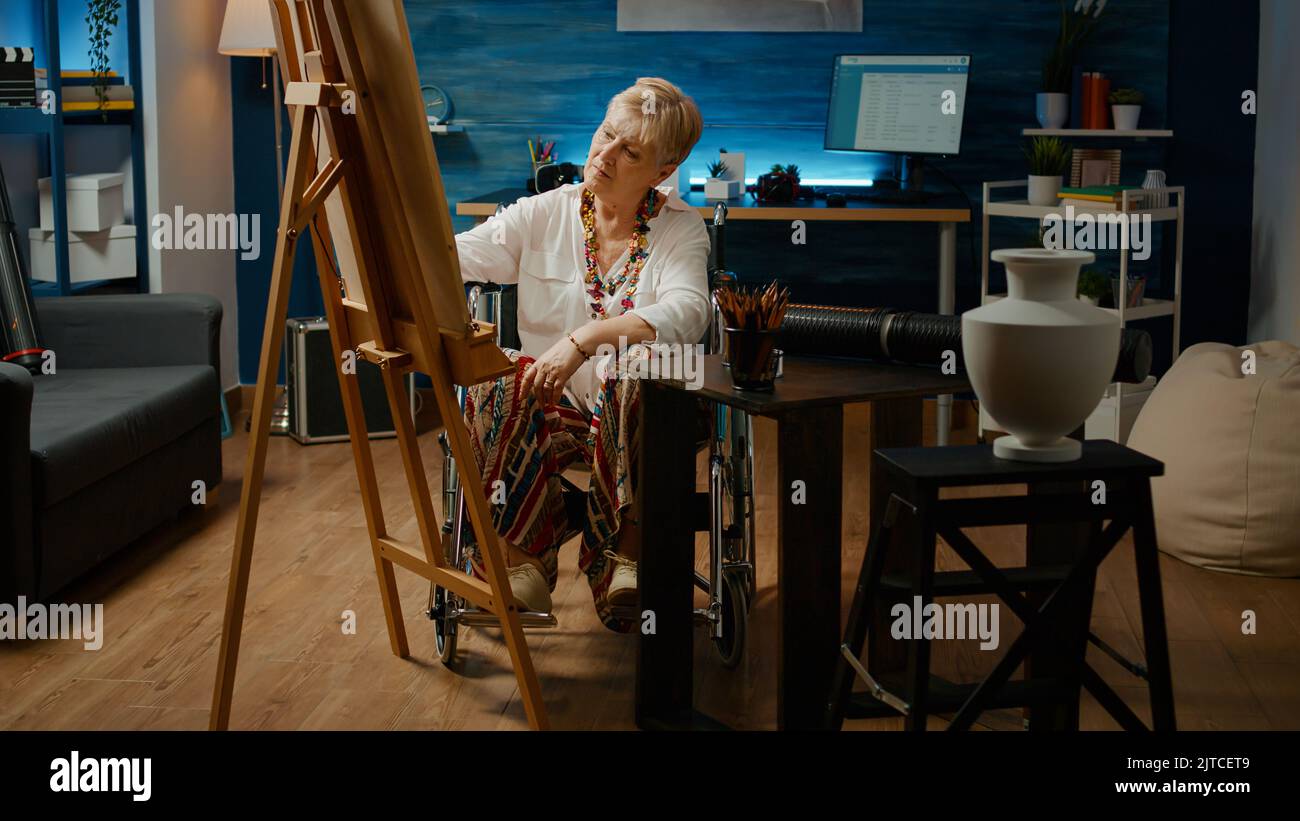 Artist dealing with chronic disability and drawing masterpiece on white