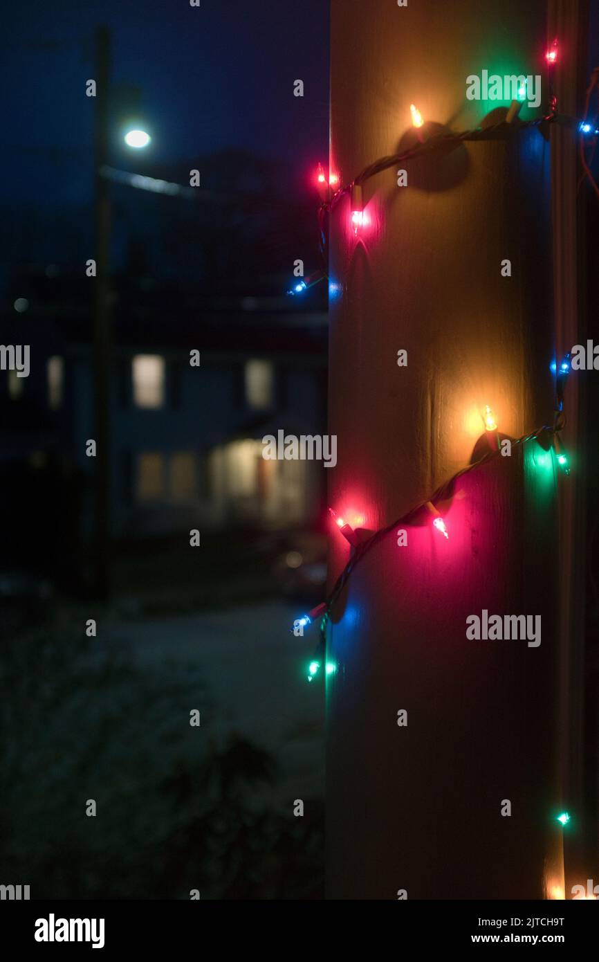Christmas Lights wrapped around Porch Column at Night Stock Photo