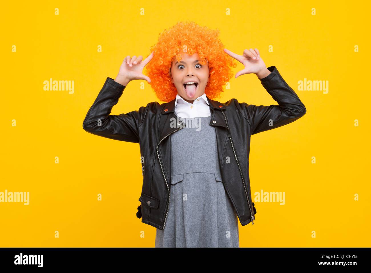 Funny face. Girl with yellow wig. Funny child wearing orange curly wig