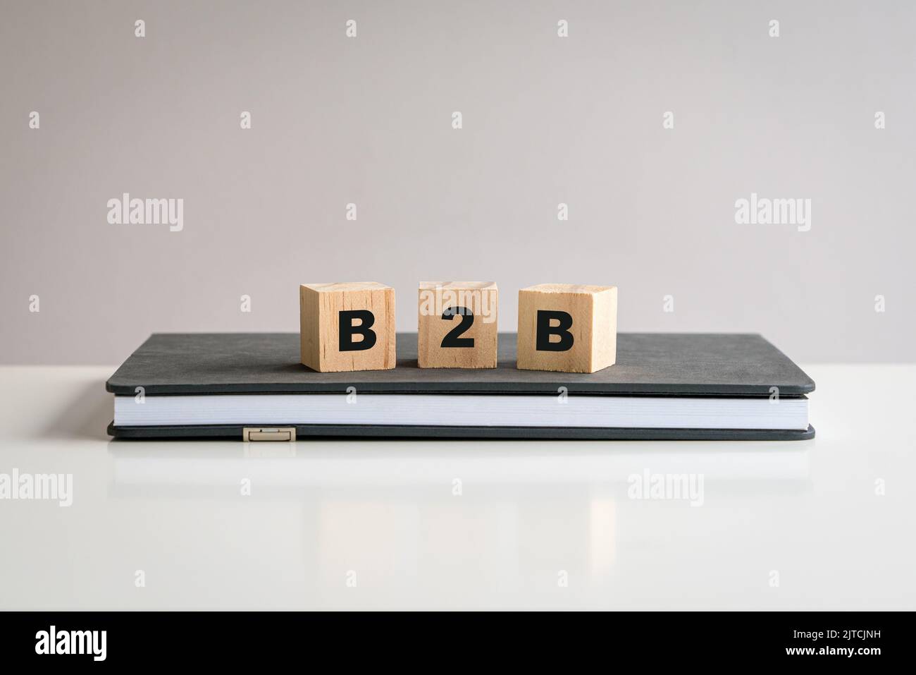 Concept of B2B. Word on wooden cubes, on top of notepad. Stock Photo