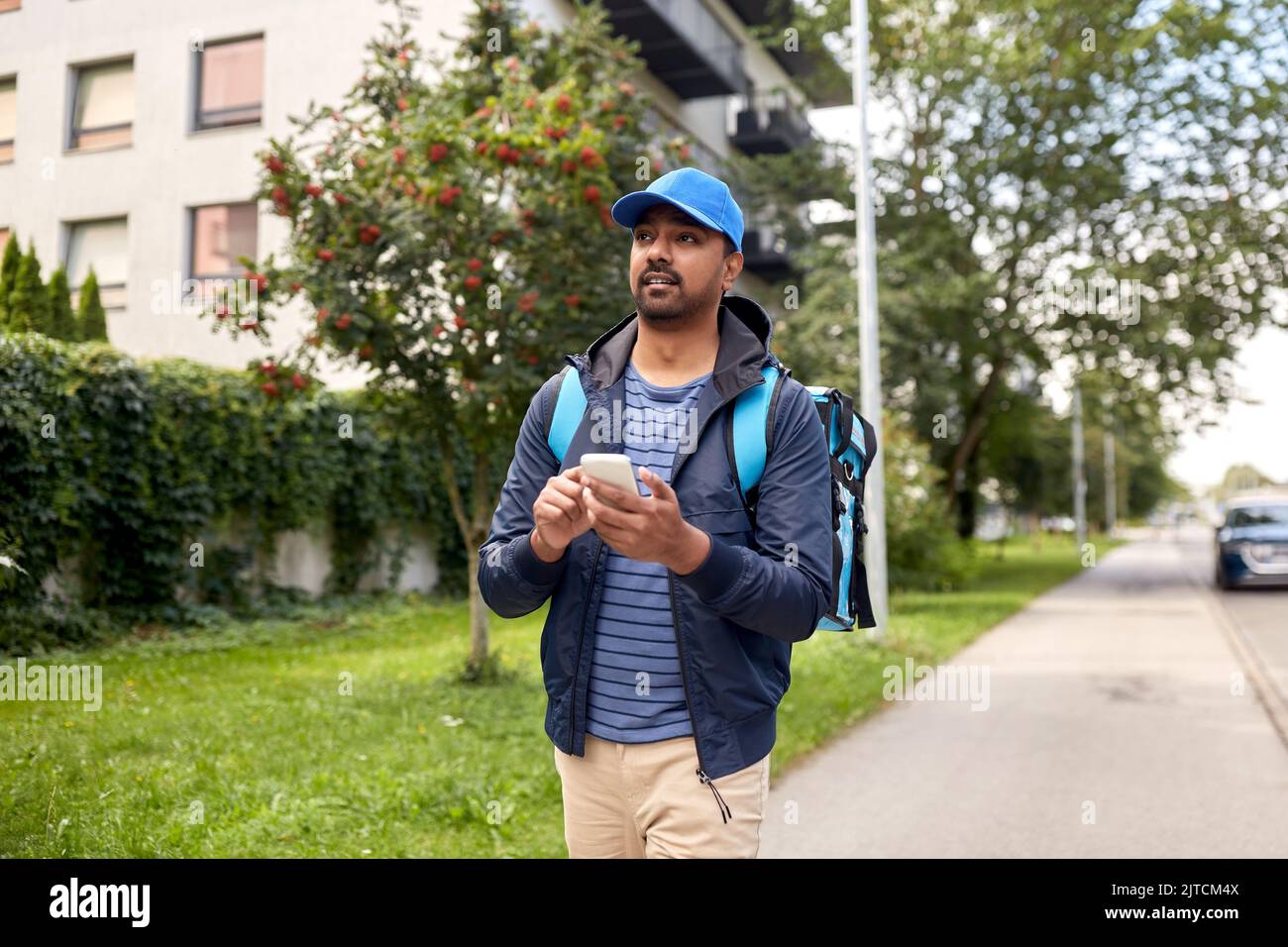 indian delivery man with bag and phone Stock Photo