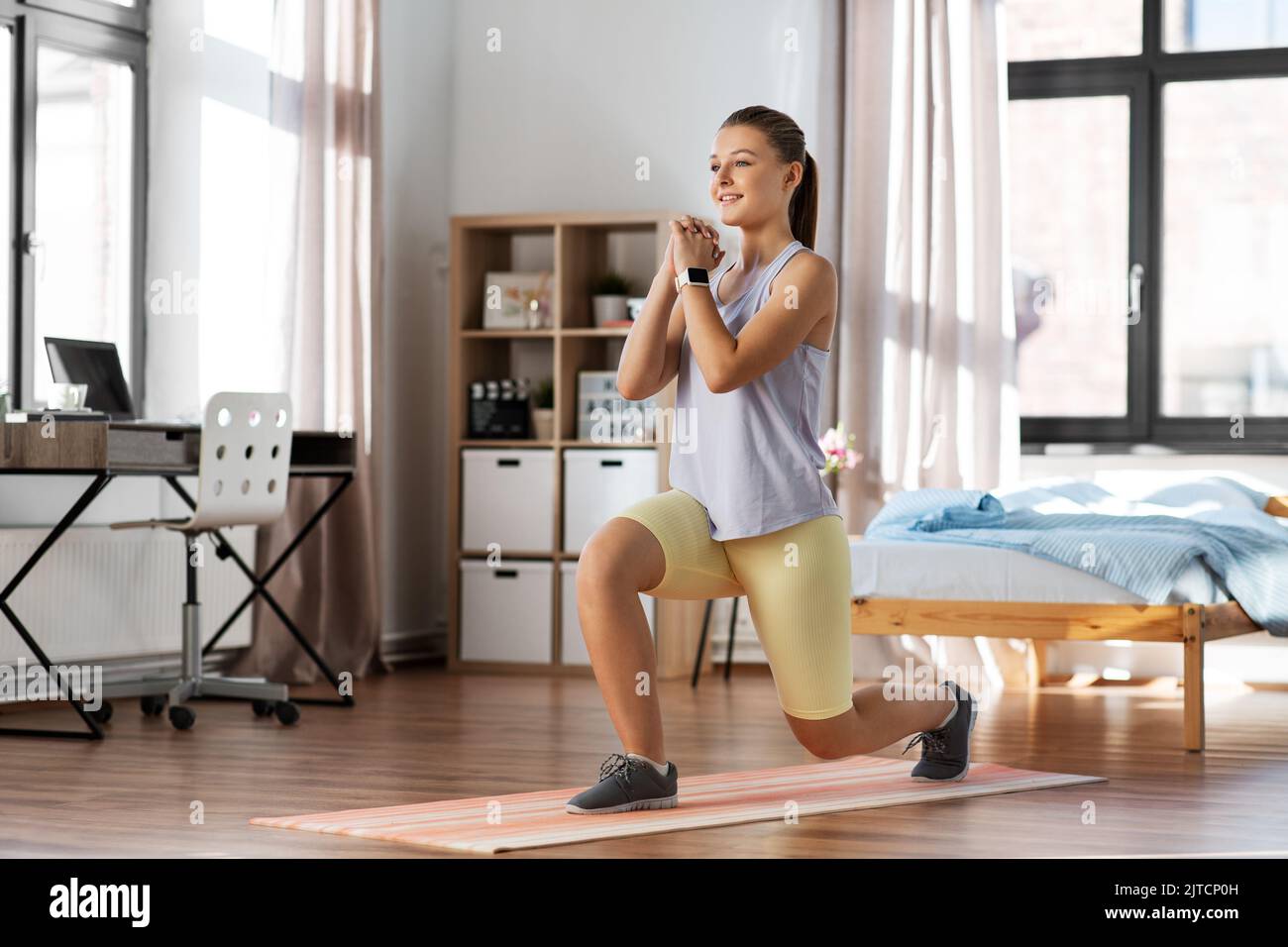 happy teenage girl exercising on yoga mat at home Stock Photo - Alamy