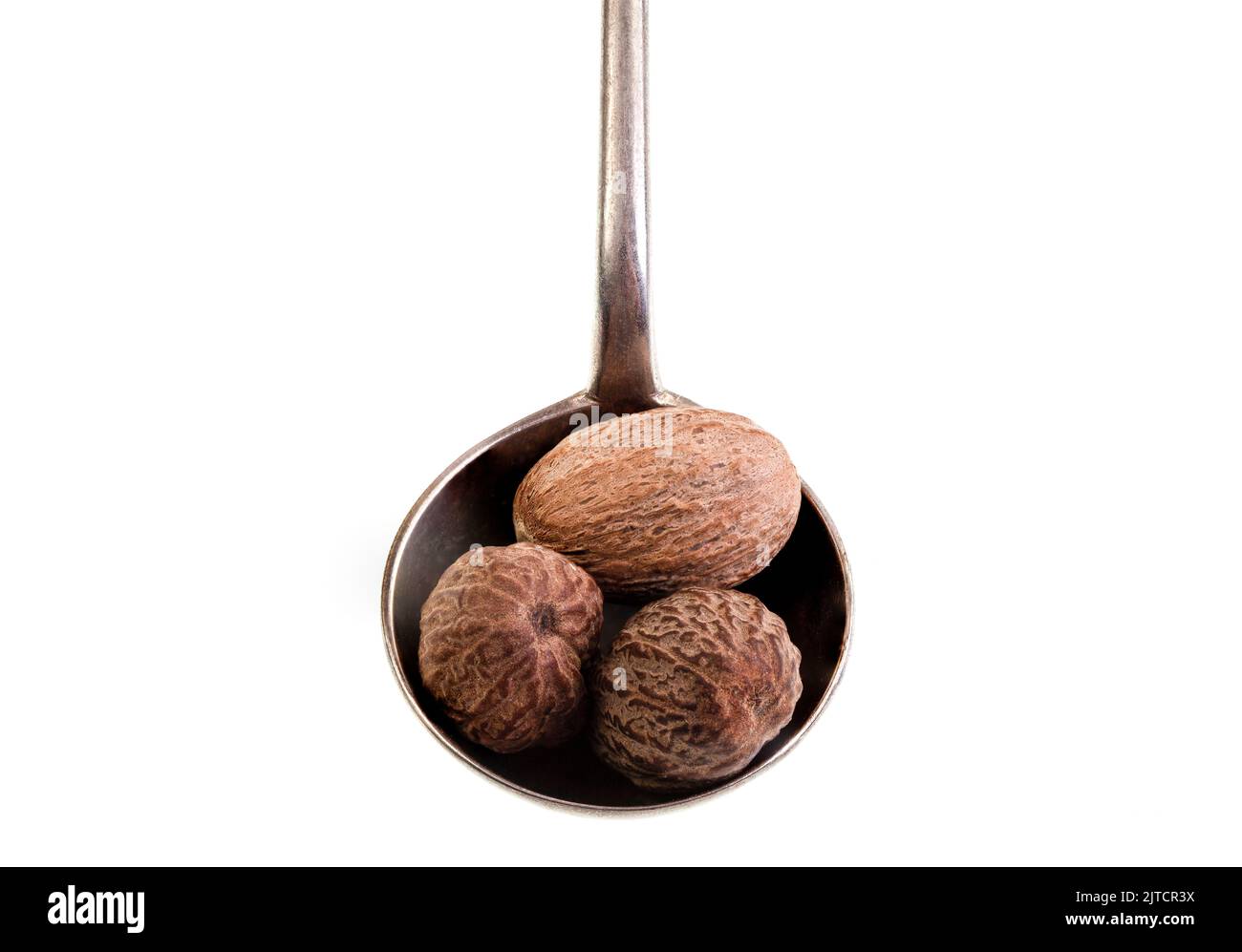 Nutmeg is the spice made by grinding the seed kernels of the fragrant nutmeg tree, Myristica fragrans, and used in many savory and sweet dishes Stock Photo