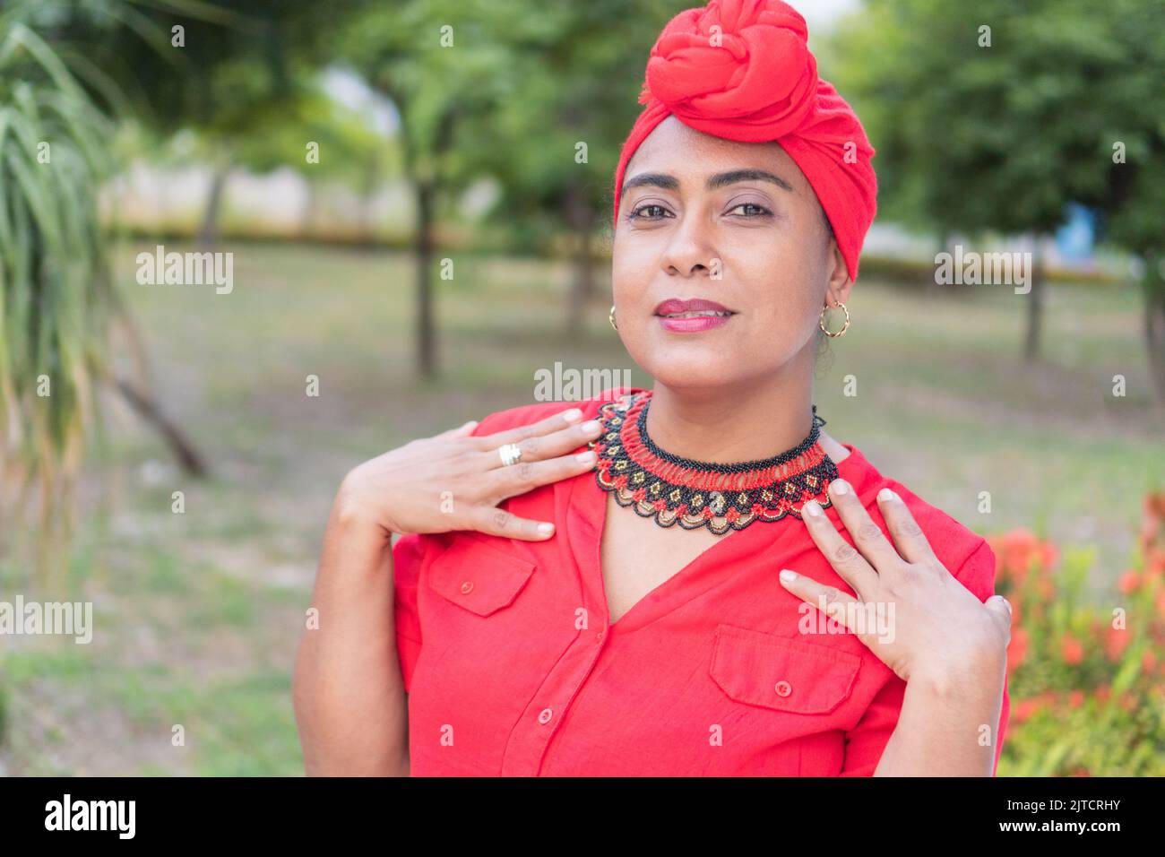 Stylish ethnic woman in ornamental clothing facing the camera with a
