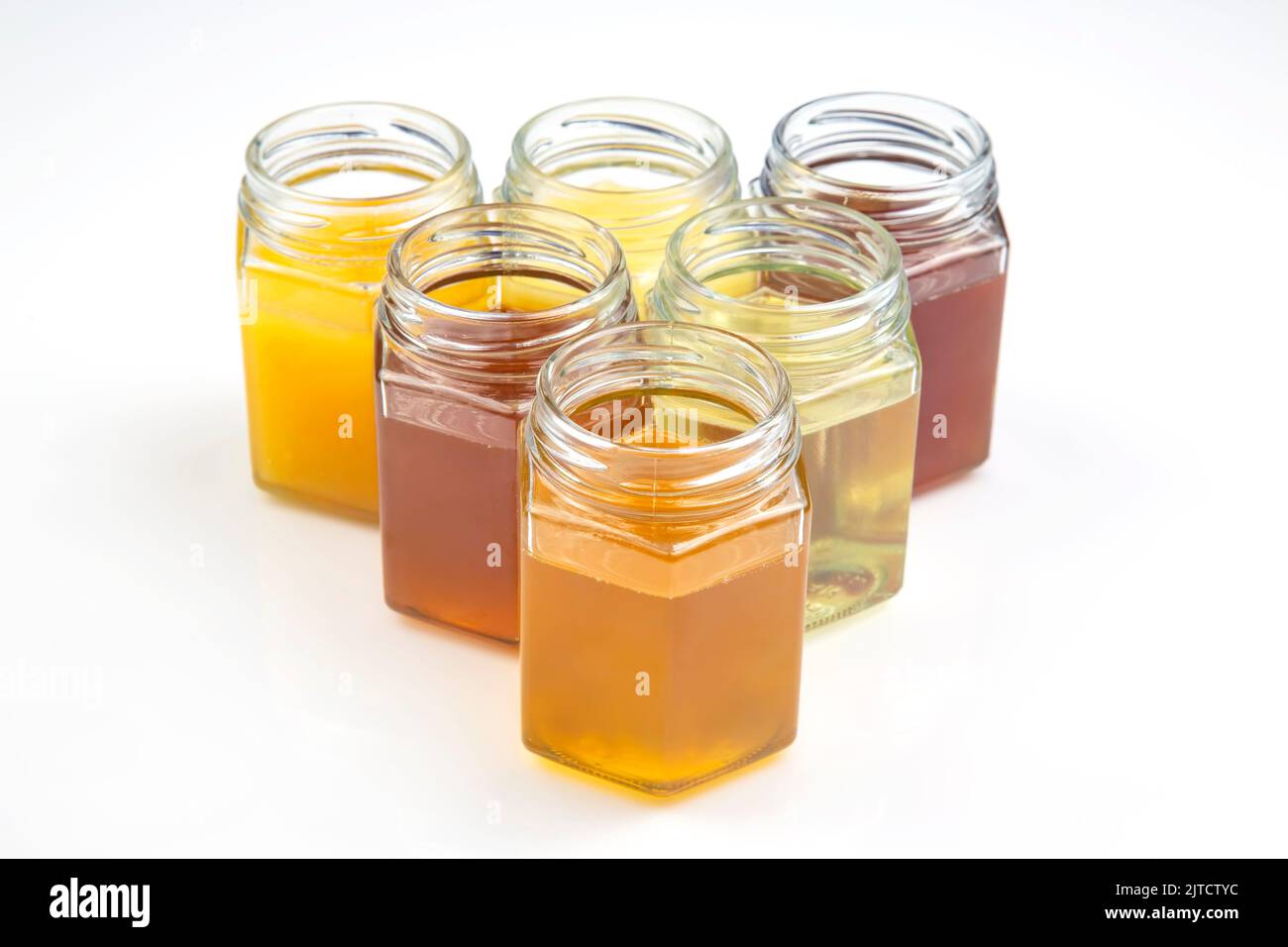 Hexagonal jars with different types and colors of fresh flower honey. vitamin food for health
