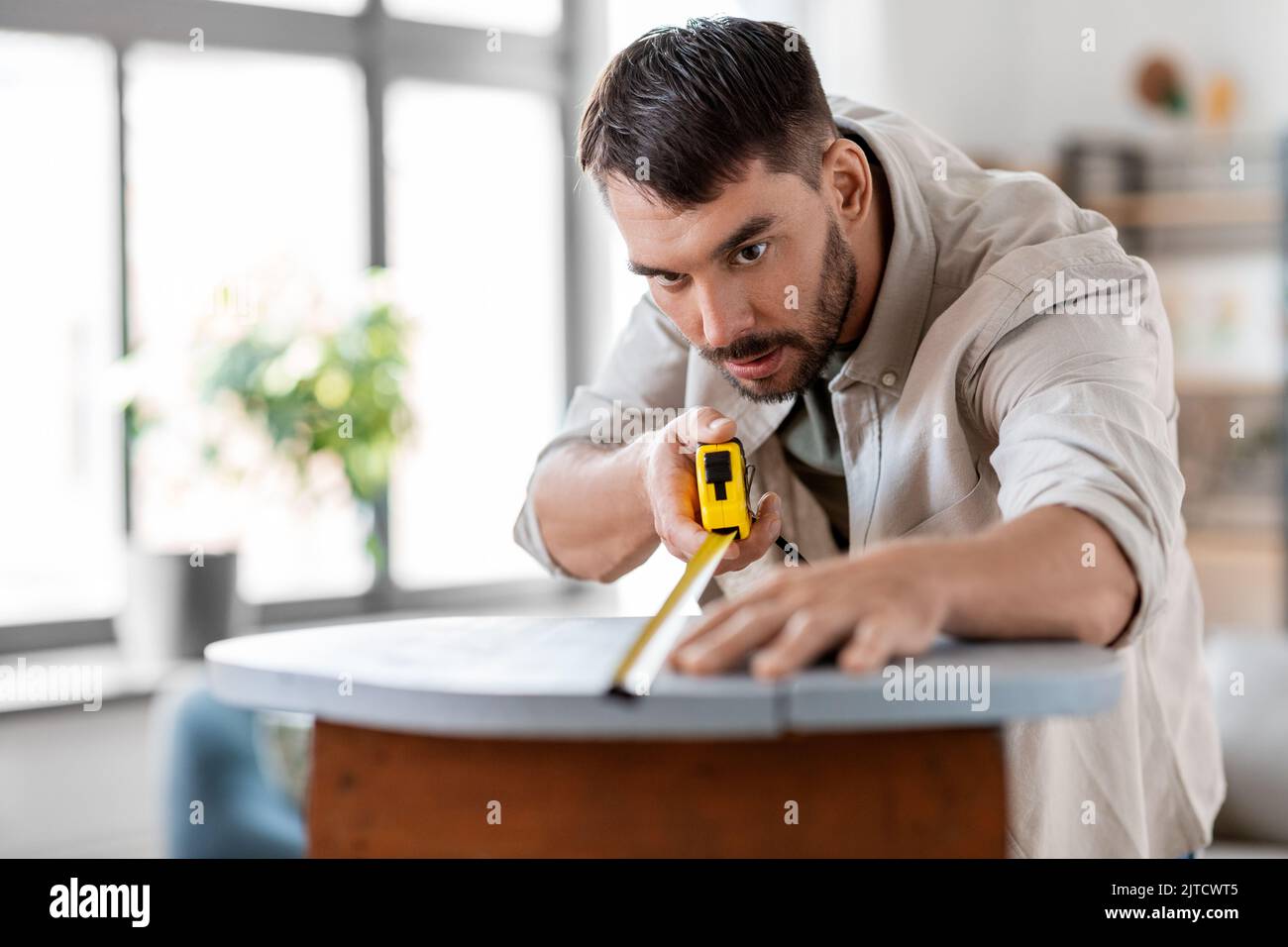man with ruler measuring table for renovation Stock Photo Alamy
