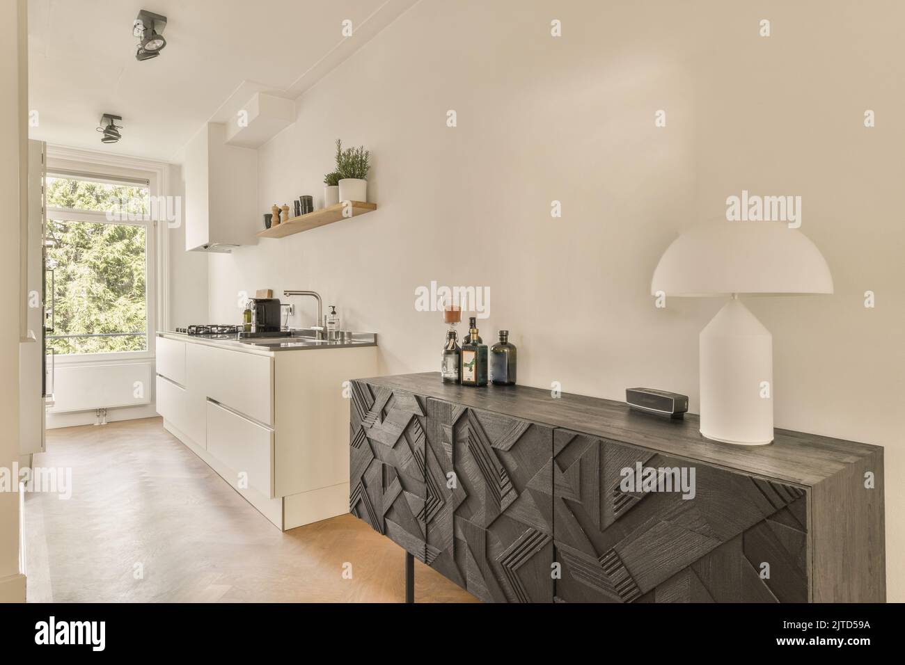Contemporary open plan kitchen with dining table set and gray sofa in