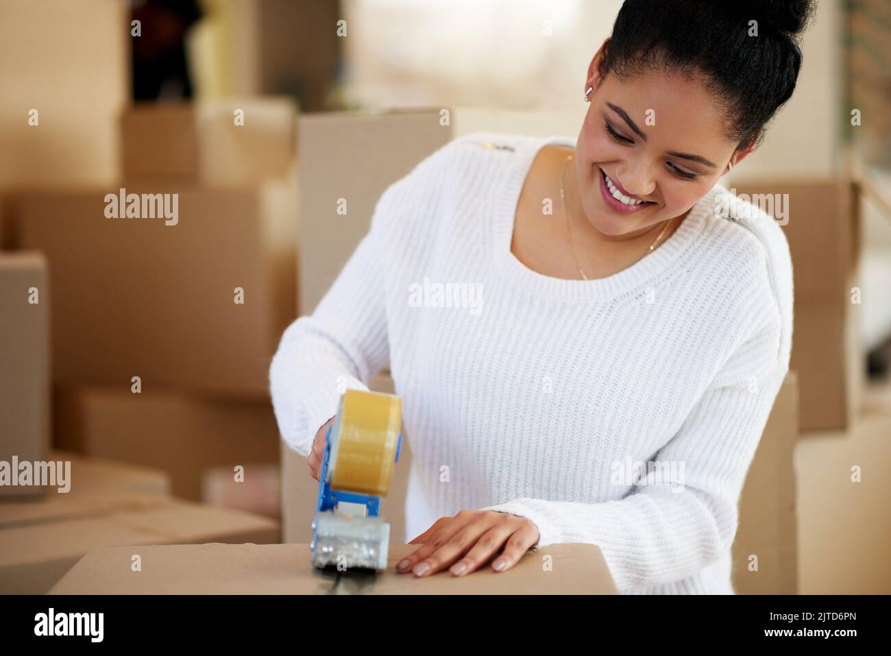 Packing her possessions for the big move. a happy young woman packing