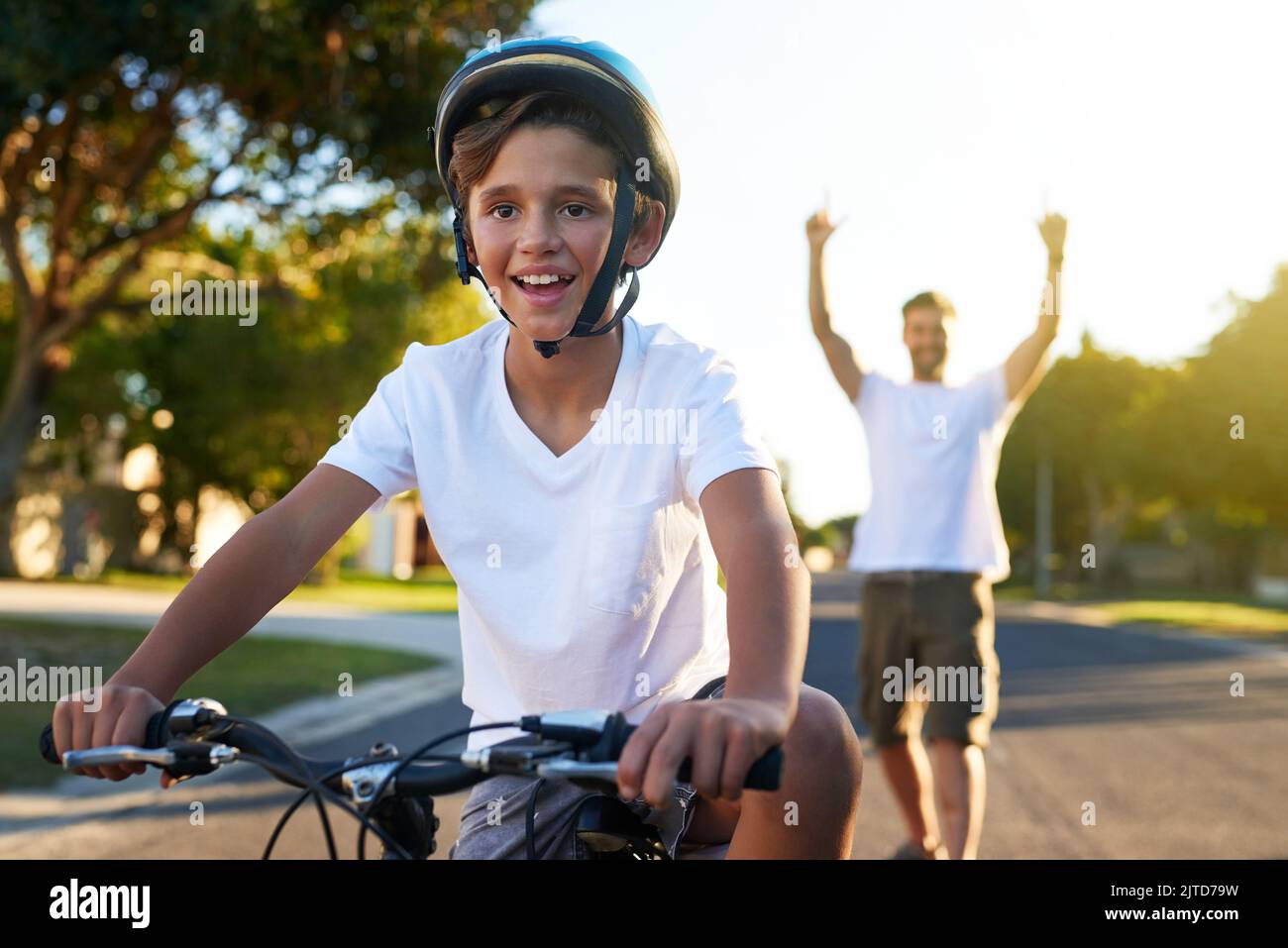 Cycling through his block. a young boy riding his bicycle through his neighbourhood. Stock Photo